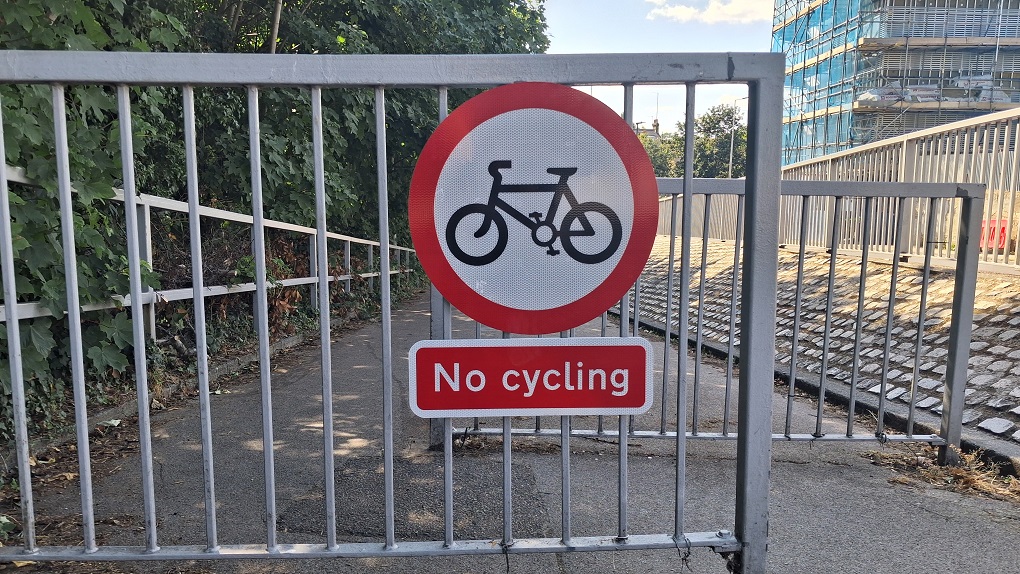 A new No Cycling sign attached to the railings beside the foot tunnel